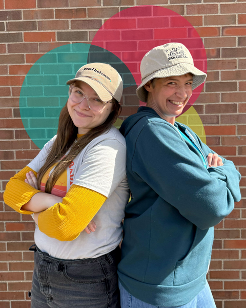 Photo features IPR talk show producer, Dani Gehr (left) wearing the Good Listener Cap and Talk of Iowa host Charity Nebbe (right) wearing the IPR Bucket Hat.
